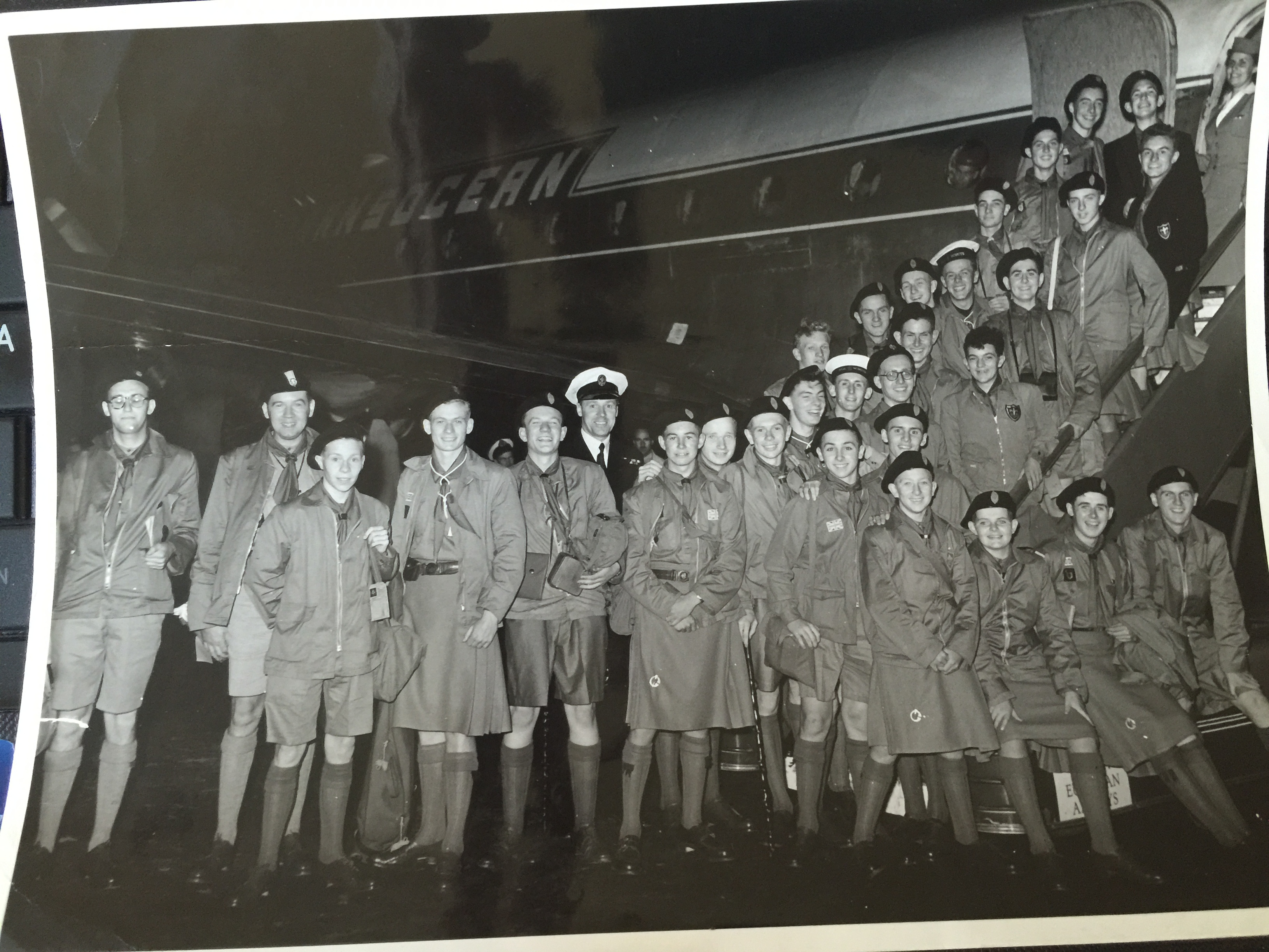 Thirty Scouts stand outside a passenger aircraft.