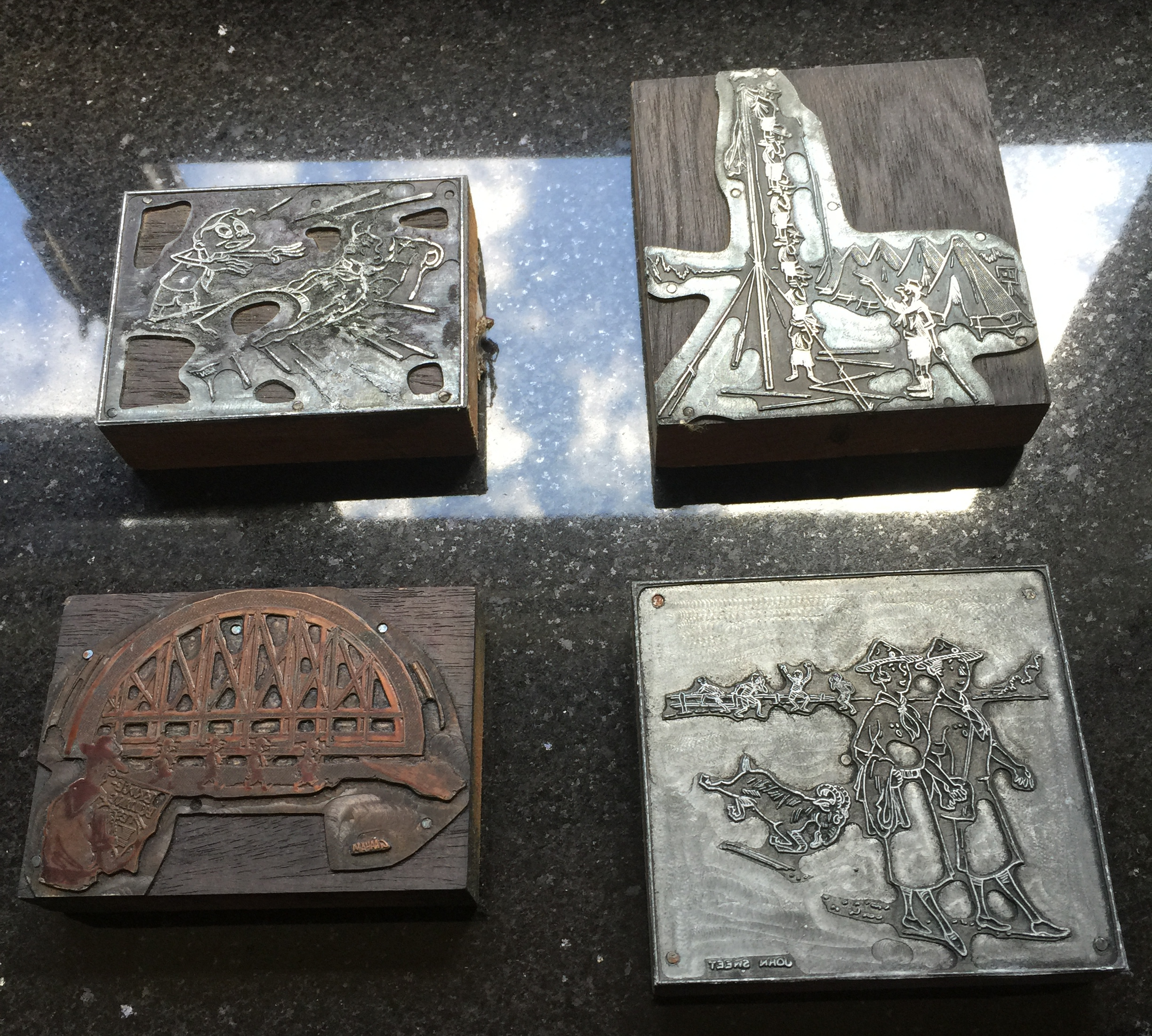 4 engraved metal pieces mounted on wood depicting in inverse different Scouting scenes.